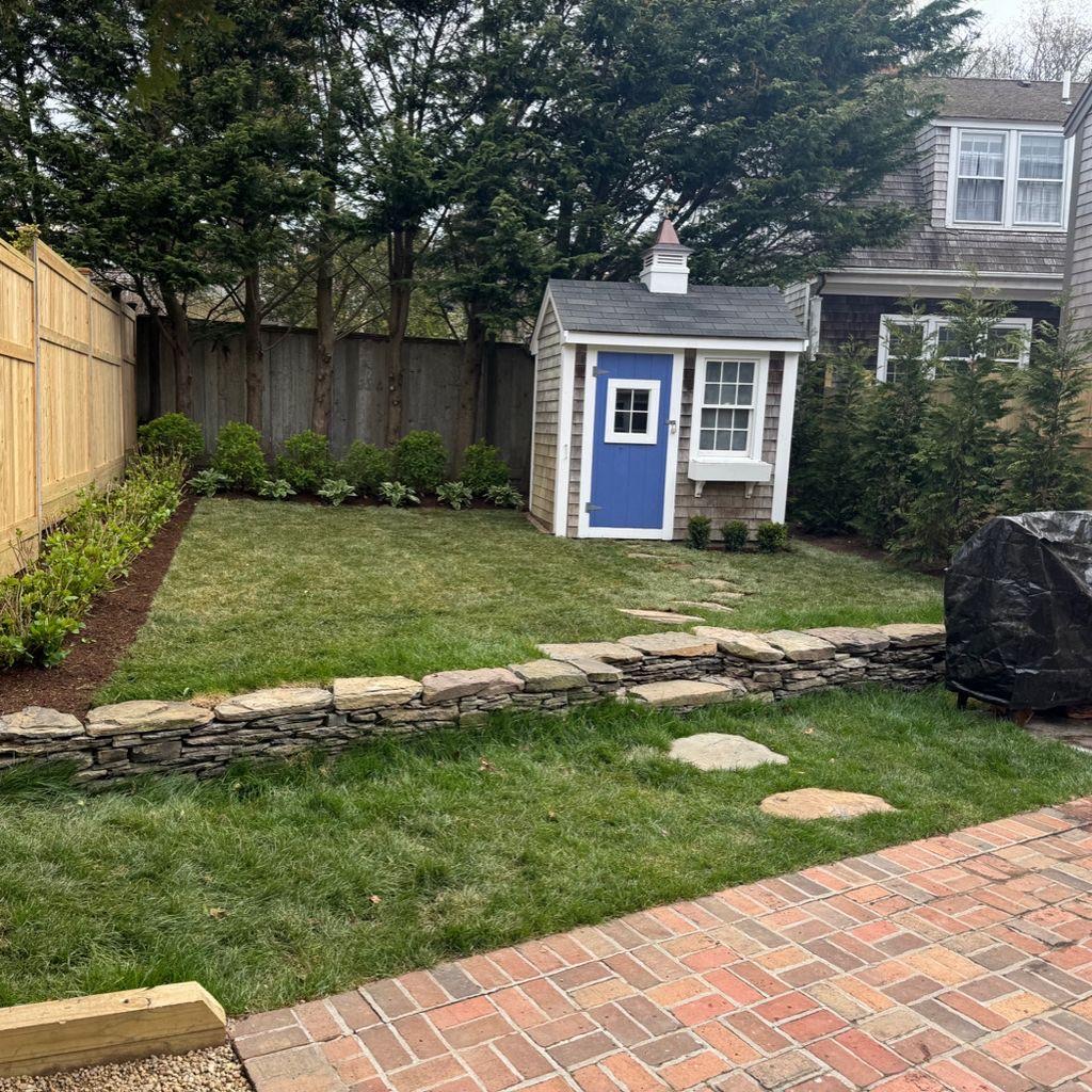 Finished Nantucket cottage garden with lawn and stone wall