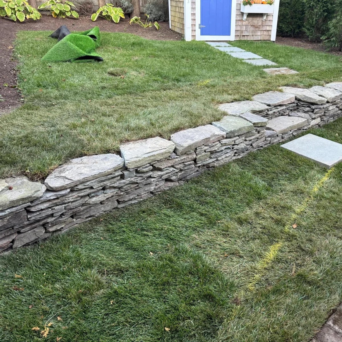 Stone wall and fresh turf installation